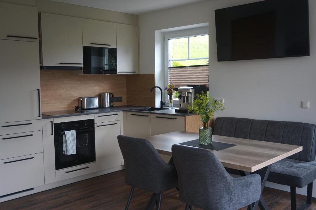 a kitchen with a wooden table with chairs and a dining room at Ferienwohnung Heidi in Mariapfarr