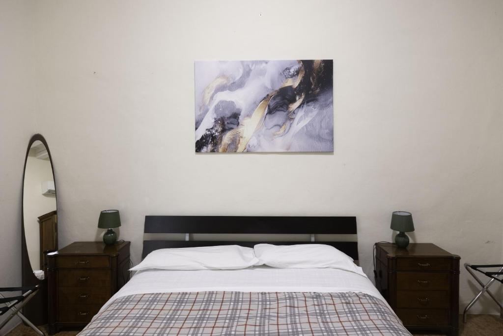 a bedroom with a bed and two dressers and a painting at Nel Cuore di Bologna V ,Bologna by Shortholidays in Bologna