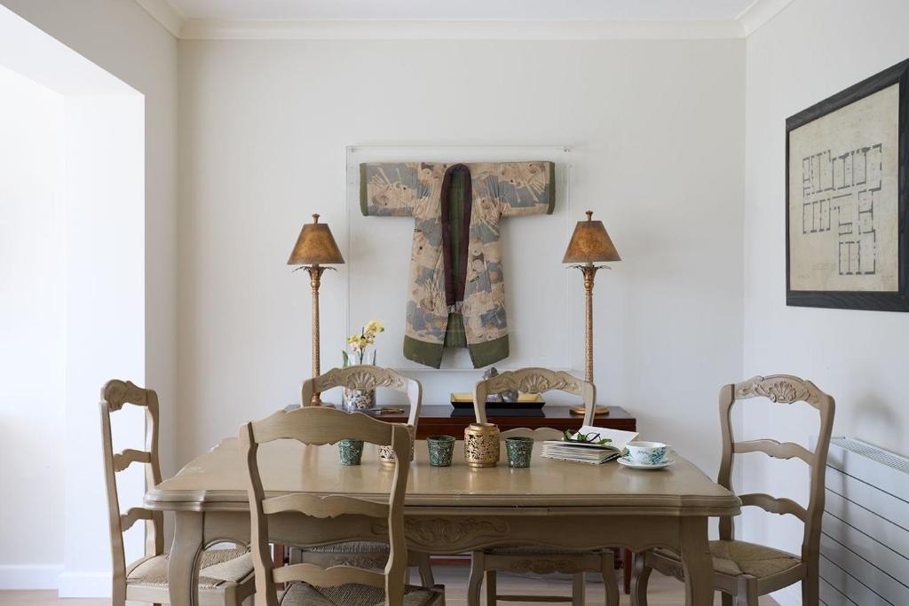 a dining room table with two chairs and a picture on the wall at Meadow Drive in Bembridge