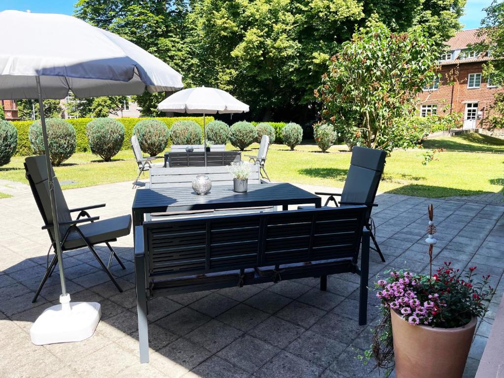 a table with two chairs and an umbrella on a patio at VITA Ferienresidenz in Neu Kaliß
