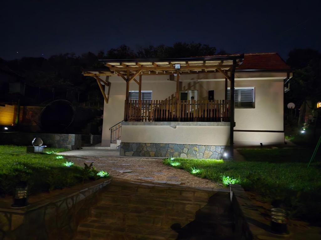 a house with a deck at night with lights at Seosko domaćinstvo Trajković in Mladenovac