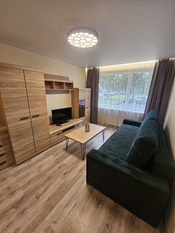 a living room with a couch and a table at Taikos apartamentai in Utena
