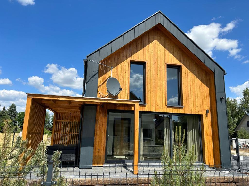 a house with a black roof at Sun House z balią in Boszkowo-Letnisko