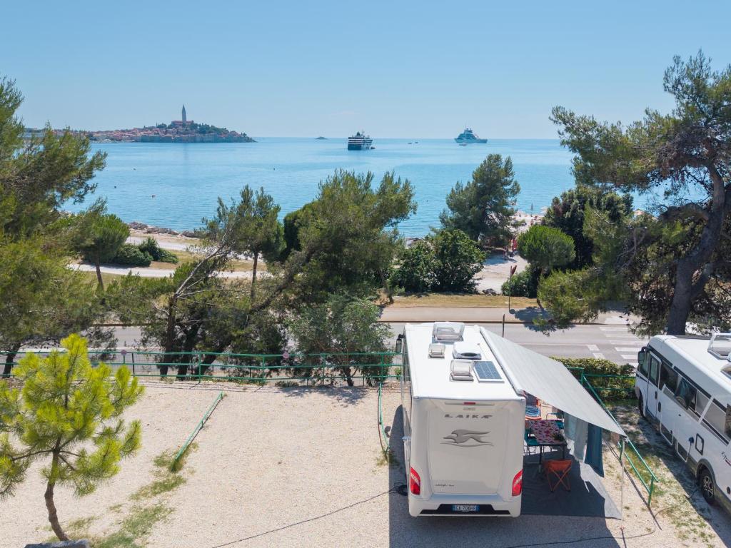 an rv parked in a parking lot next to the water at Porton Nature Hideouts Pitches in Rovinj