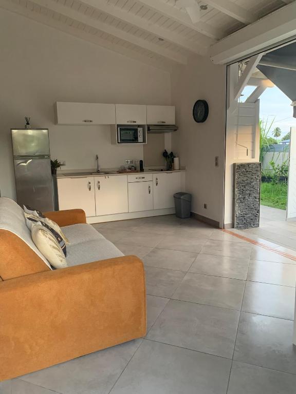a living room with a couch and a kitchen at Chez BIBI in Grand-Bourg