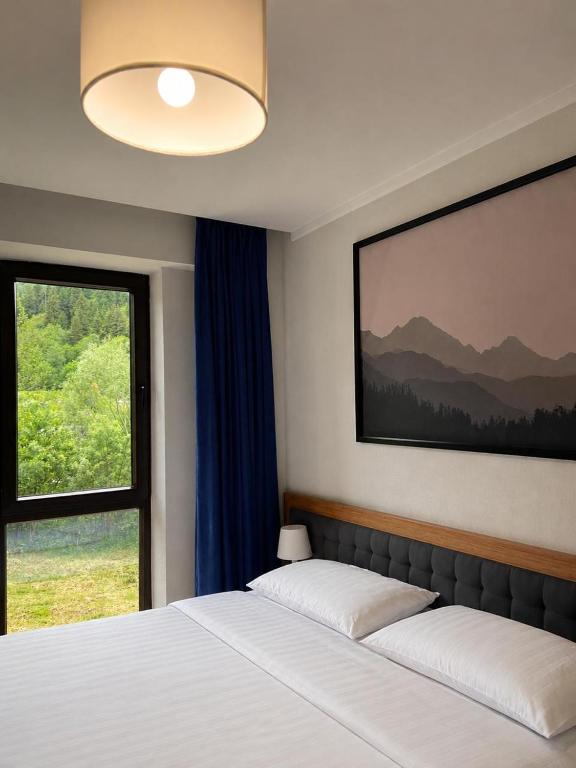 a bedroom with a bed and a large window at Aparthotel Room 107 at Orbi Palace in Bakuriani in Bakuriani