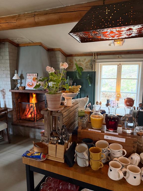 a room with a table with cups and a fireplace at Bondasgården in Lima