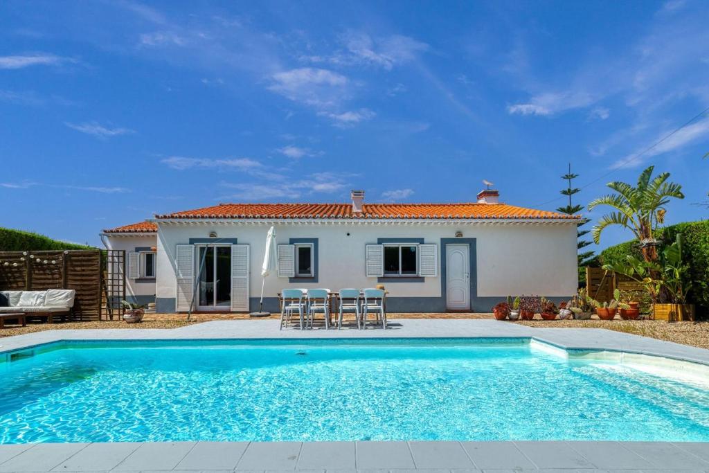 a villa with a swimming pool in front of a house at AnchorHouse Portugal in Aljezur