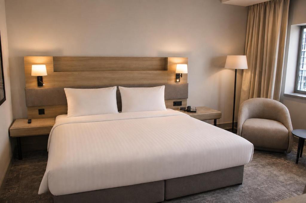 a hotel room with a large bed and a chair at Radisson Blu Hotel, Liverpool in Liverpool