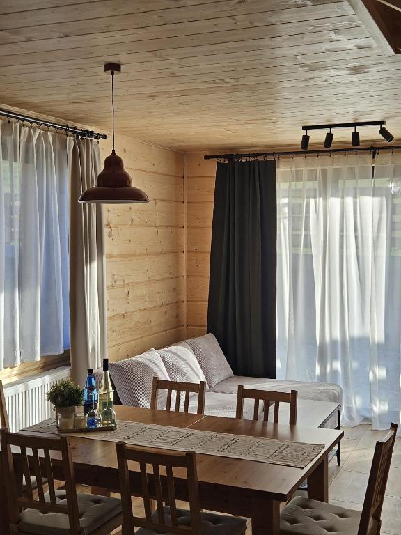 a dining room with a table and a couch at Tatrzańska Osada 2 - Domki przy stoku narciarskim w Białce Tatrzańskiej in Białka Tatrzańska