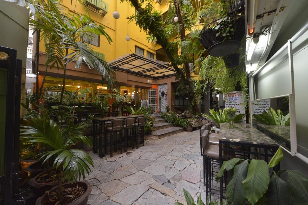 a restaurant with a patio with tables and plants at Sourire at Rattanakosin Island Hotel in Bangkok