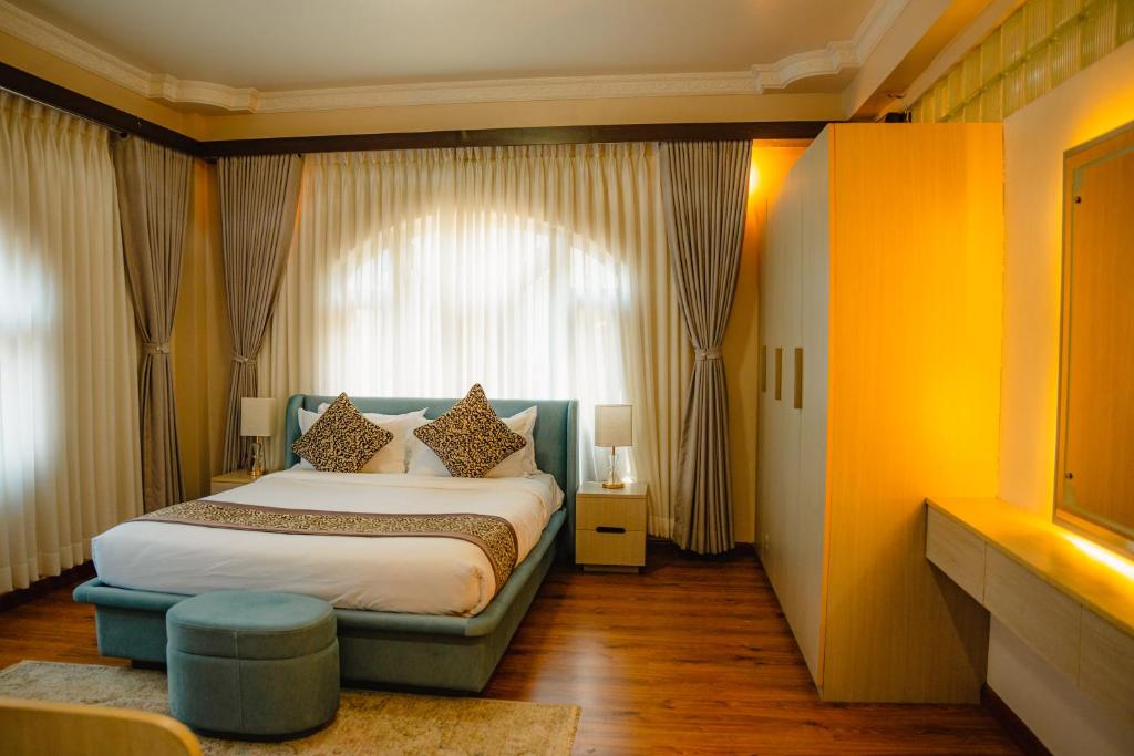 a bedroom with a bed and a large window at Devi Aura Villa in Burhānilkantha