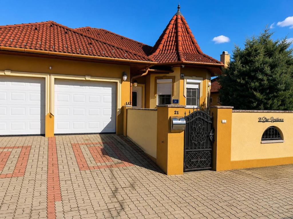 a house with two garage doors and a tile roof at 21 Star Residence in Darnózseli
