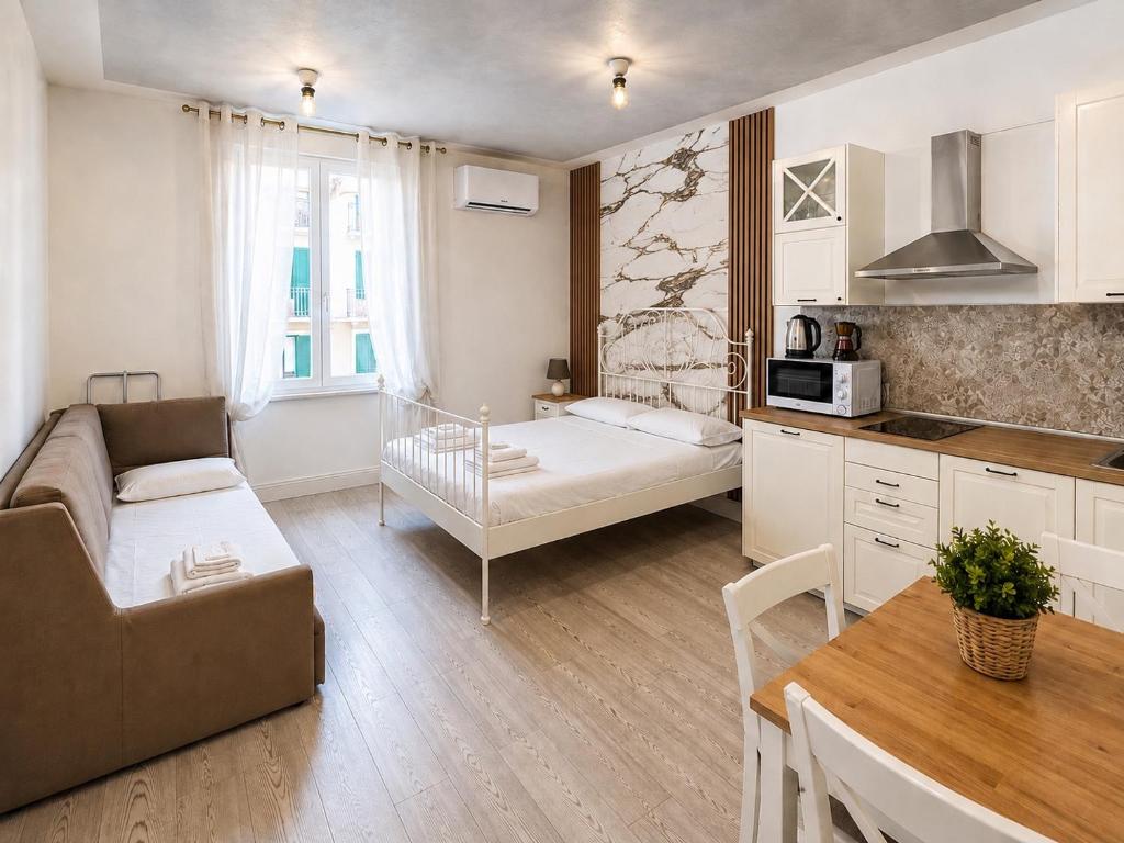 a kitchen and living room with a couch and a table at Cinque Terre Sweet Home - Centro La Spezia - 5 min stazione - Ideale Cinque Terre - WiFi e AC in La Spezia