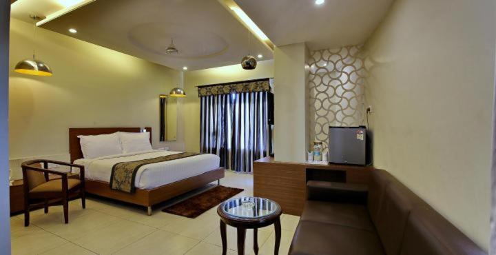 a bedroom with a bed and a tv in a room at Hotel Sheela Shree Plaza in Jhānsi