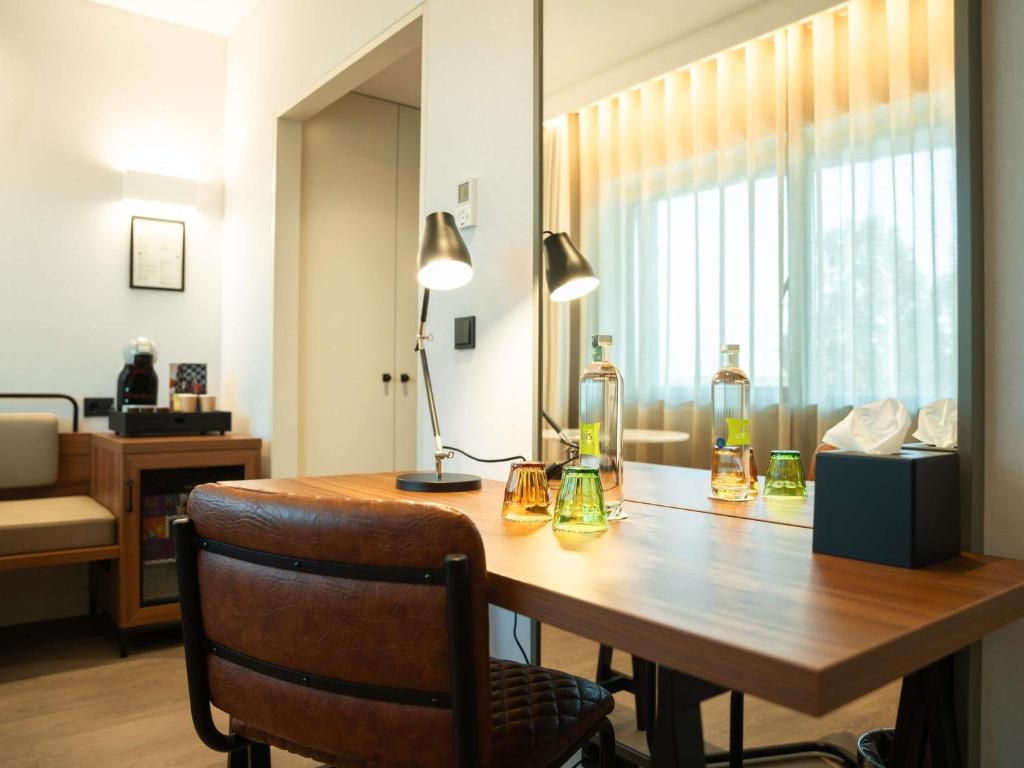 A well-equipped in-room desk beside a large curtained window.