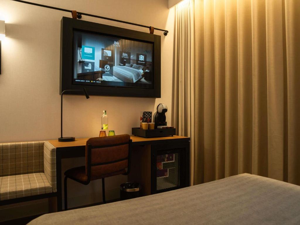 A guest room view focused on the wall-mounted television and compact work area.