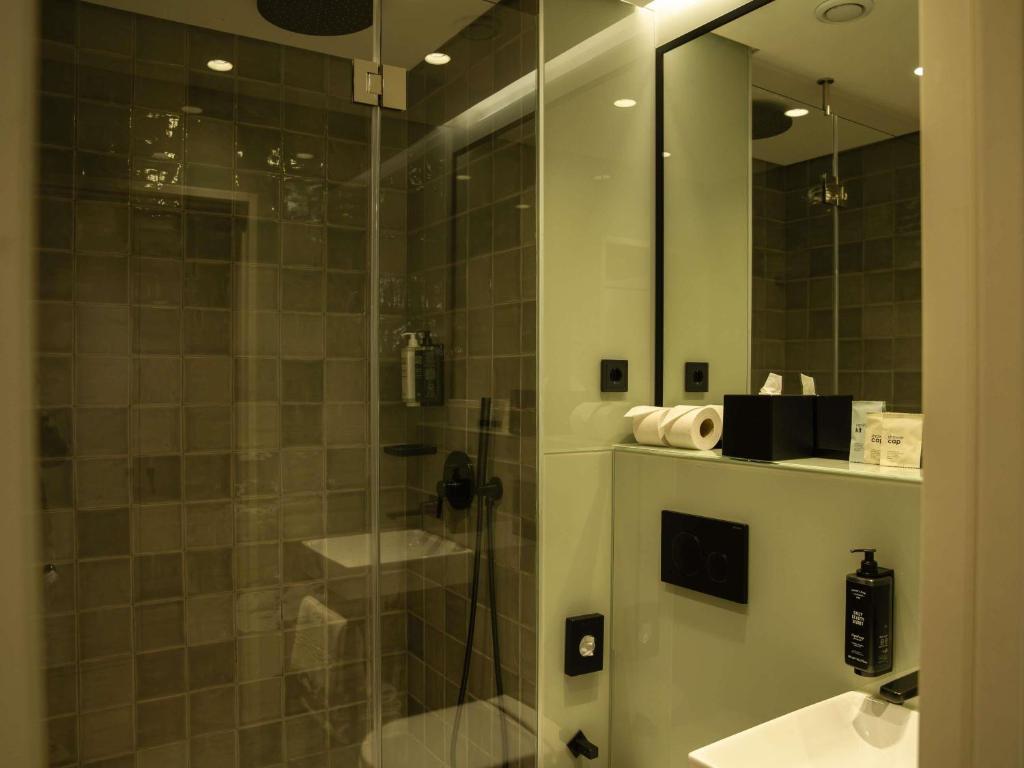 A glass-enclosed walk-in shower beside a contemporary bathroom vanity.