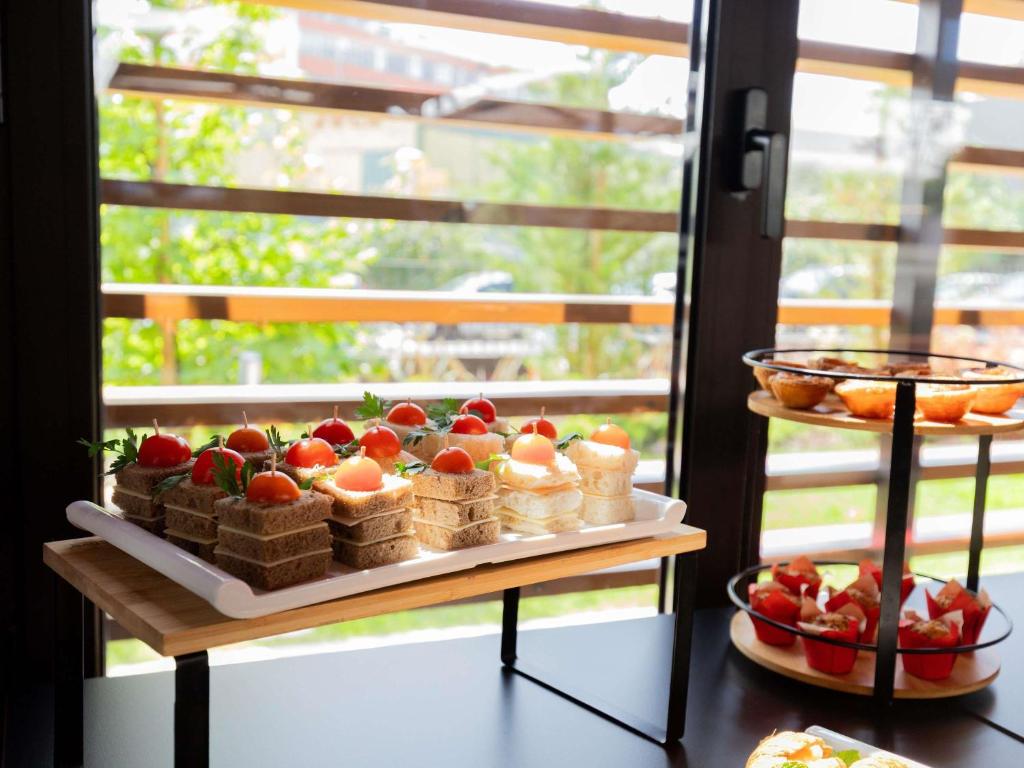 A close-up of small fruit-topped breakfast cakes and pastries beside a window.