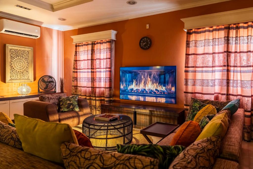a living room with a couch and a flat screen tv at Luxe Oasis Palma in Quatre Bornes