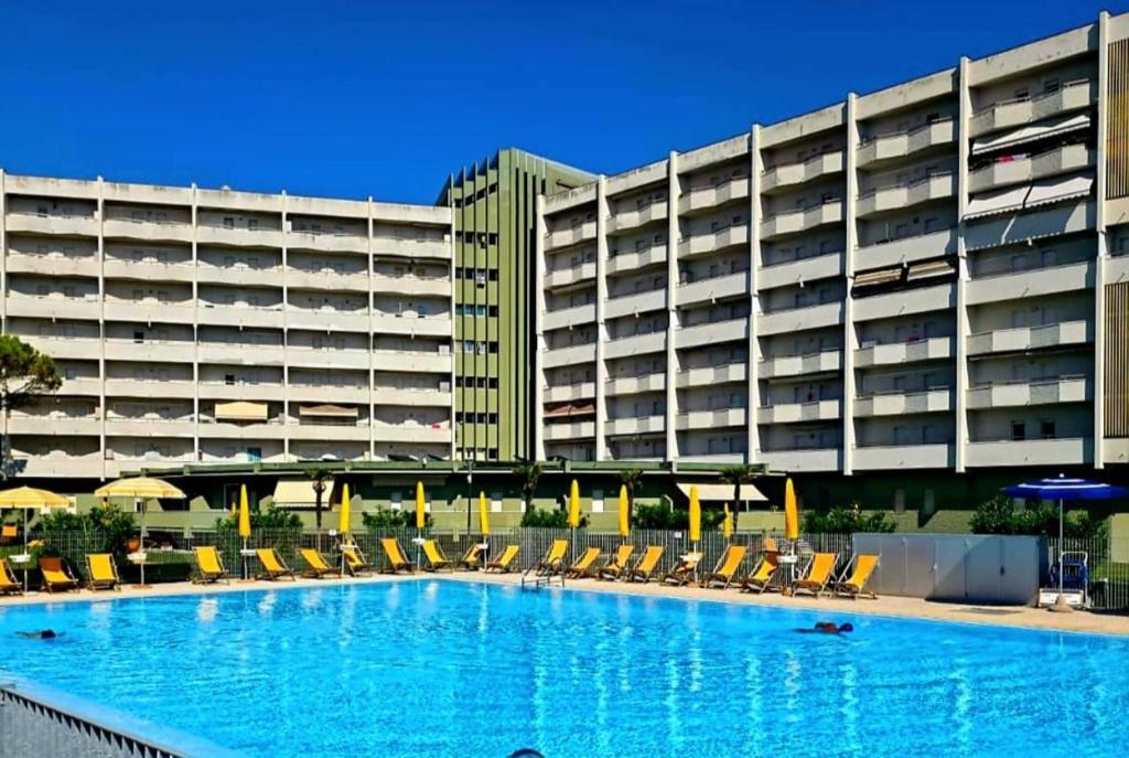 a large hotel with a swimming pool in front of a building at Residence di Raul in Porto Recanati