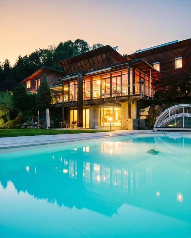 a house with a swimming pool in front of a house at Alpine Sunlight Villa in Villach