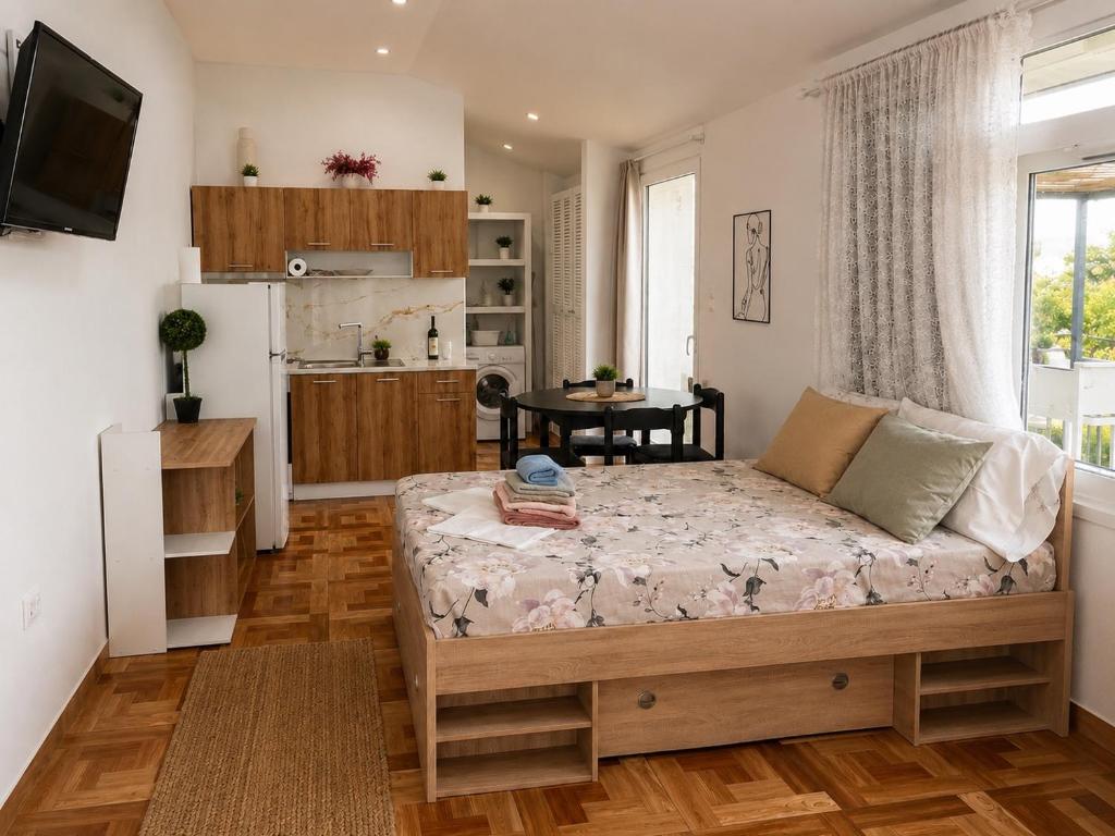 a living room with a bed and a kitchen at Sofita garden in Nea Michaniona