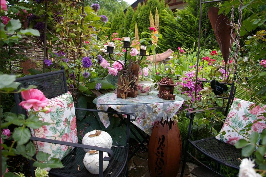 a table and chairs in a garden with flowers at Thalerhof-Markus in Roppen