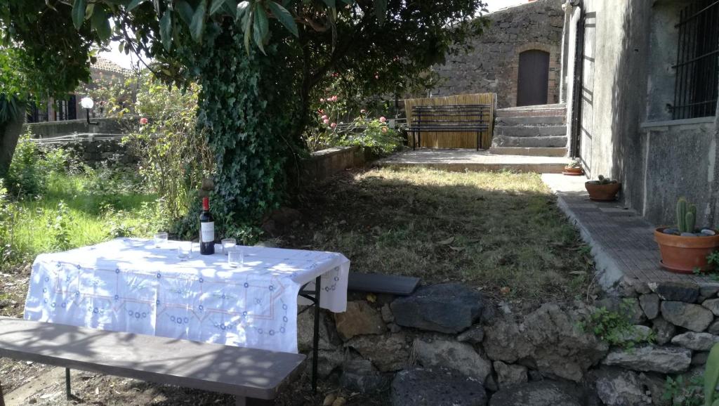 a table with a wine bottle on it in a garden at Casa rustica in SantʼAlfio