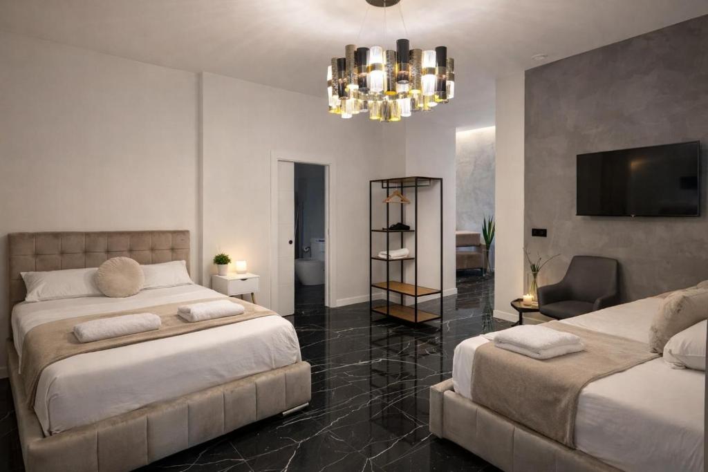 a bedroom with two beds and a chandelier at LEMIGA SUiTE VALENCIA in Valencia