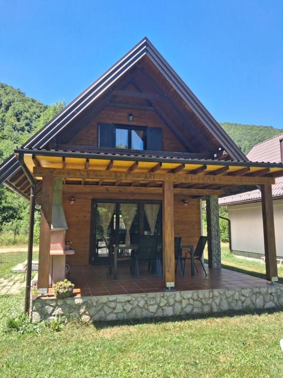 a wooden pavilion with a deck in the grass at Vacation home Zara in Lohovo