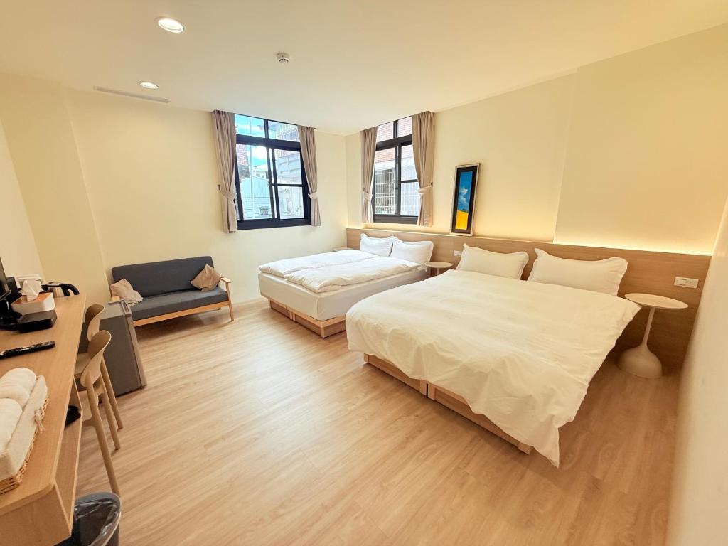 a bedroom with a bed and a couch in it at Jian Guo Hotel in Pingtung City