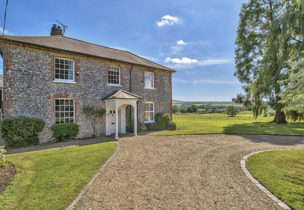 an old stone house with a gravel driveway at Timberley House by Group Retreats in Pulborough