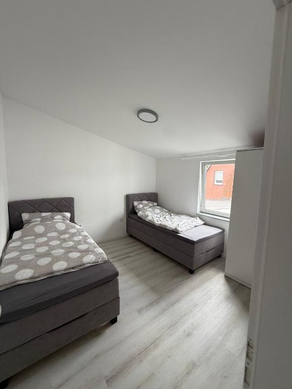 a bedroom with two beds and a window at Deluxe Apartment II in Velpke