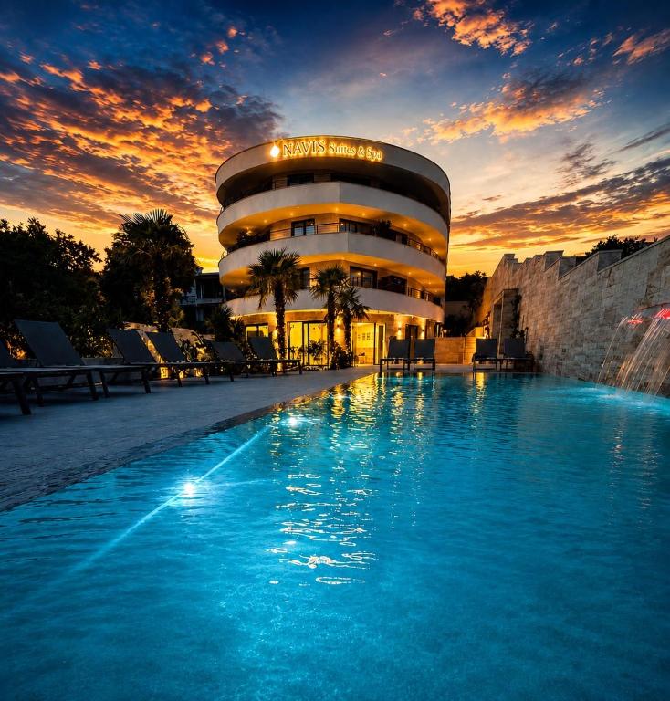 a hotel with a swimming pool in front of a building at Navis Suites & Spa in Mandre