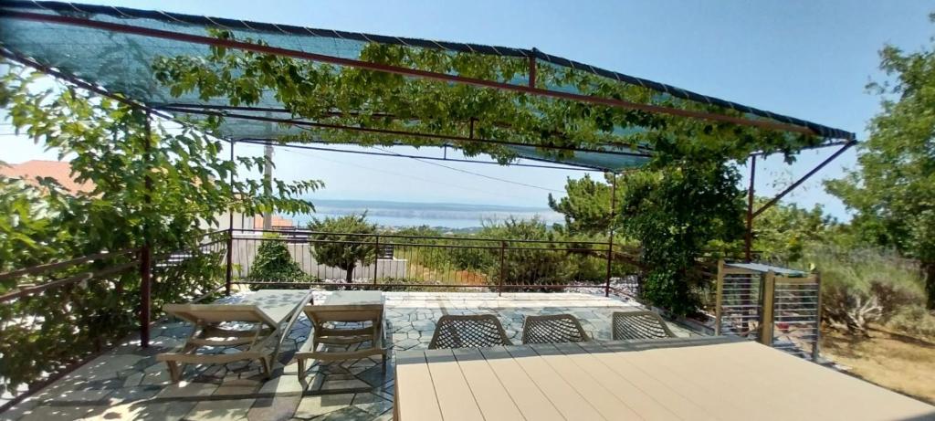 a patio with a table and chairs on a deck at Apartment Tušek in Jadranovo