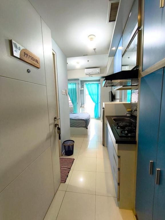 a kitchen with a door to a room with a bed at Studio Apartemen Parahyangan Residence by Anton in Bandung