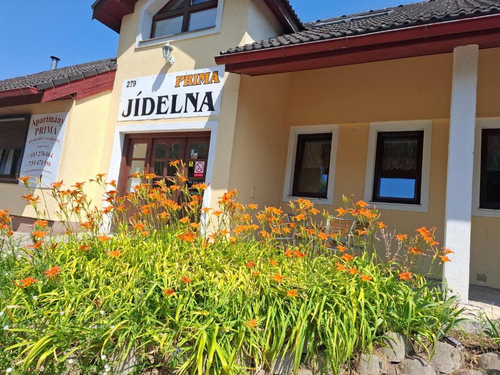 a building with a flower garden in front of it at Apartmány Prima-Pokoje in Mimoň
