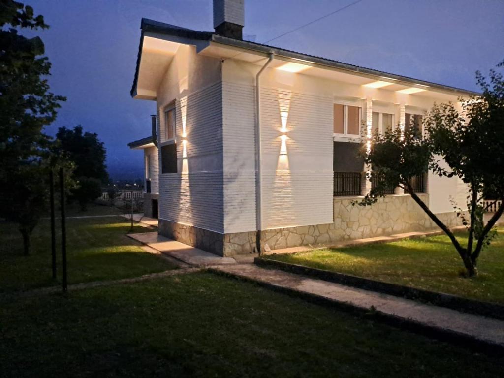 a white house with lights on the side of it at Rosales Collection Vacation Villa in Medina de Pomar