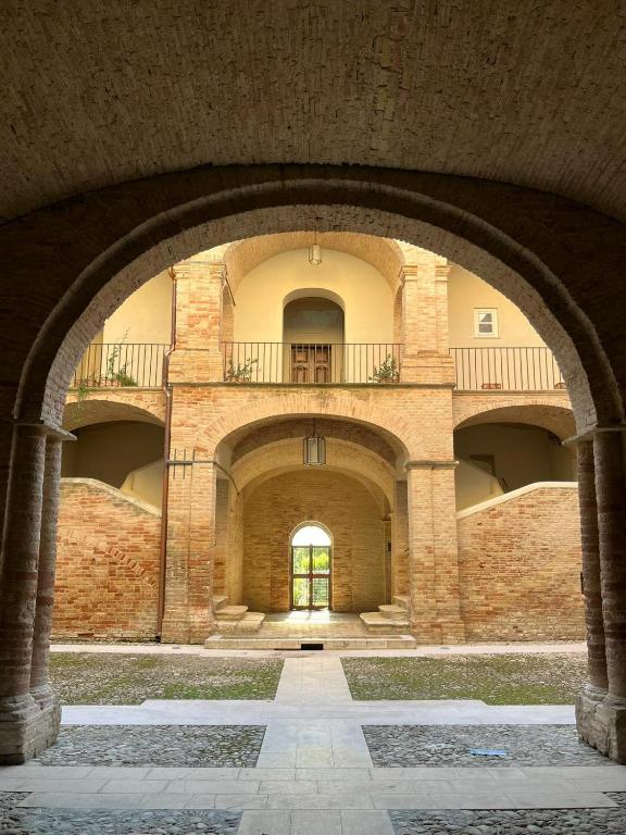 an archway in a brick building with a balcony at Dimora Palazzo De Luca - Intra Alborgodiffuso - Loft di Charme del 700 con Vasca doppia e Camino in Serracapriola