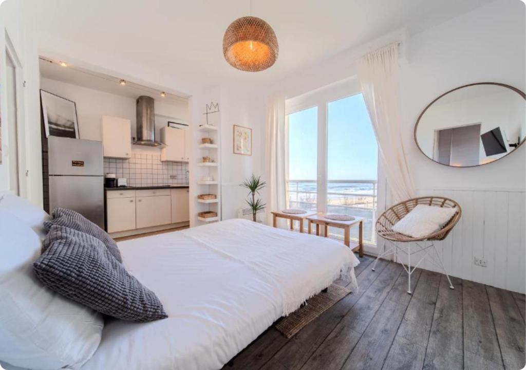 a bedroom with a large bed and a large window at Appartement à la Centrale avec vue Océan in Soorts-Hossegor
