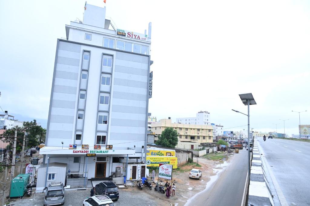 a tall white building on the side of a street at Hotel Siya Grand in Tirupati