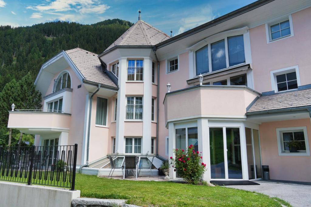 a large pink house with a mountain in the background at Grütter Luxury Apartments in Ischgl