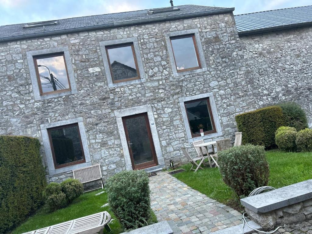 a stone building with a bench in front of it at Private room with king size bed - shared bathroom in Clavier