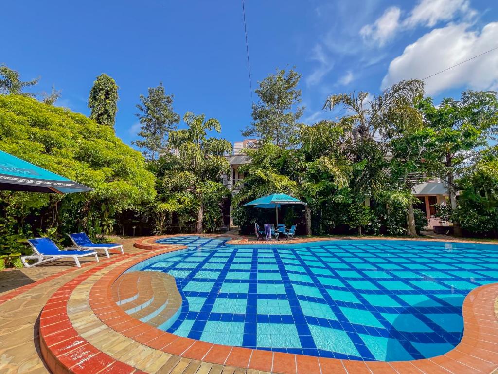 a swimming pool with blue tiles on the ground at Fiche Villas in Mombasa