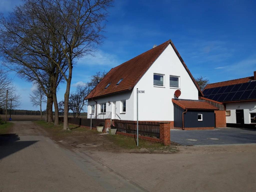 a white house with a brown roof and a street at Ferienwohnungen in Böhme in Böhme