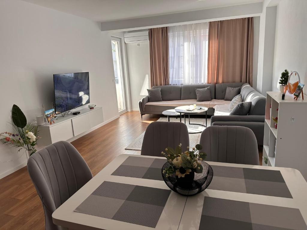a living room with a couch and a table with chairs at Bright flat in Fushë Kosova in Kosovo Polje