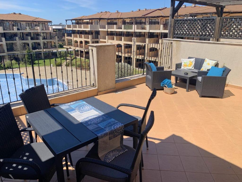 a patio with a table and chairs on a balcony at Kaliakria Pearl Resort in Topola