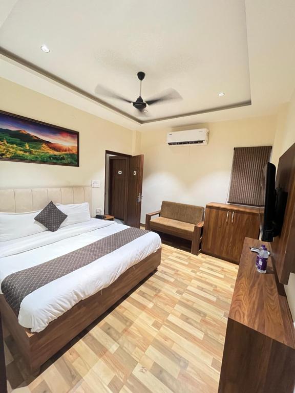 a bedroom with a bed and a tv and a couch at RS Galaxy Near AIMS Rishikesh in Rishīkesh