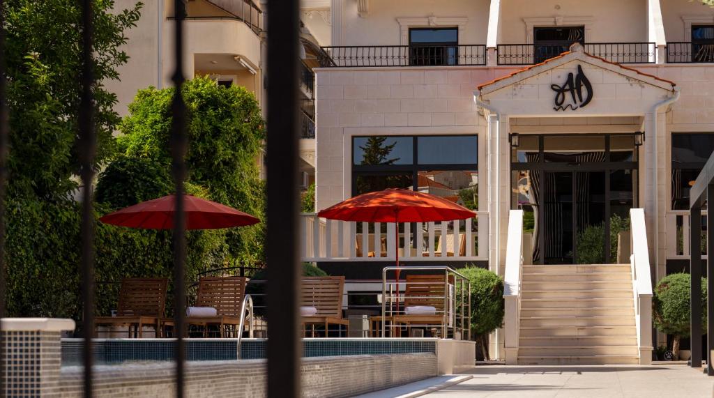two red umbrellas in front of a building at Hotel Aquarius Dubrovnik in Dubrovnik